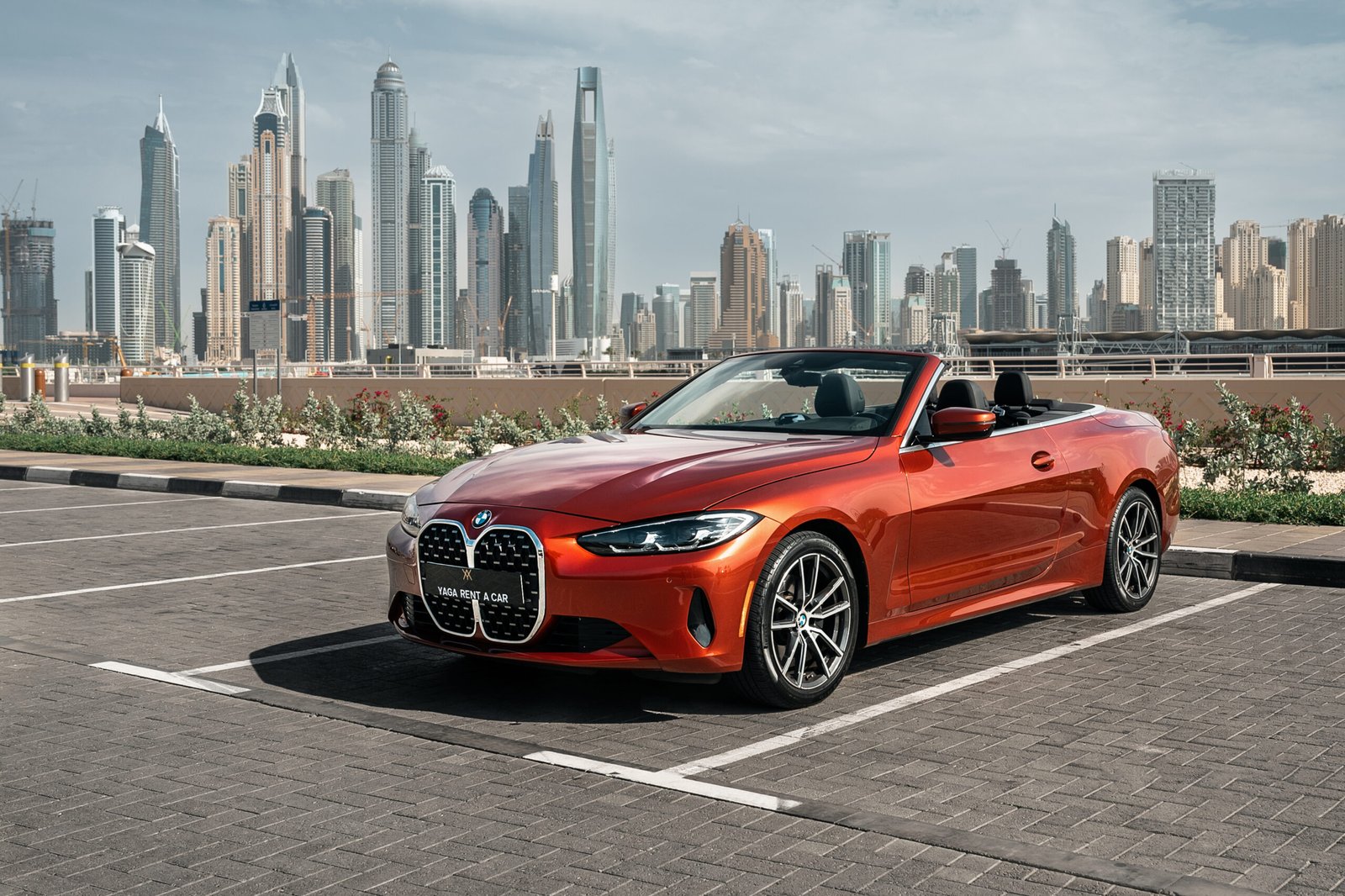 BMW 4 Series onvertible parked under sunny Dubai sky.
